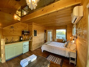 A wooden cabin with a kitchen, a bed, and a bathroom. - Coach's Quarters - The Dugout - Come Spend The Night in the Trees!! (Waco)