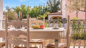 A table with a plate of fruit, a cup, and a vase with flowers. - Le Residenze Del Golfo Di Orosei Bilo 5 (Orosei)