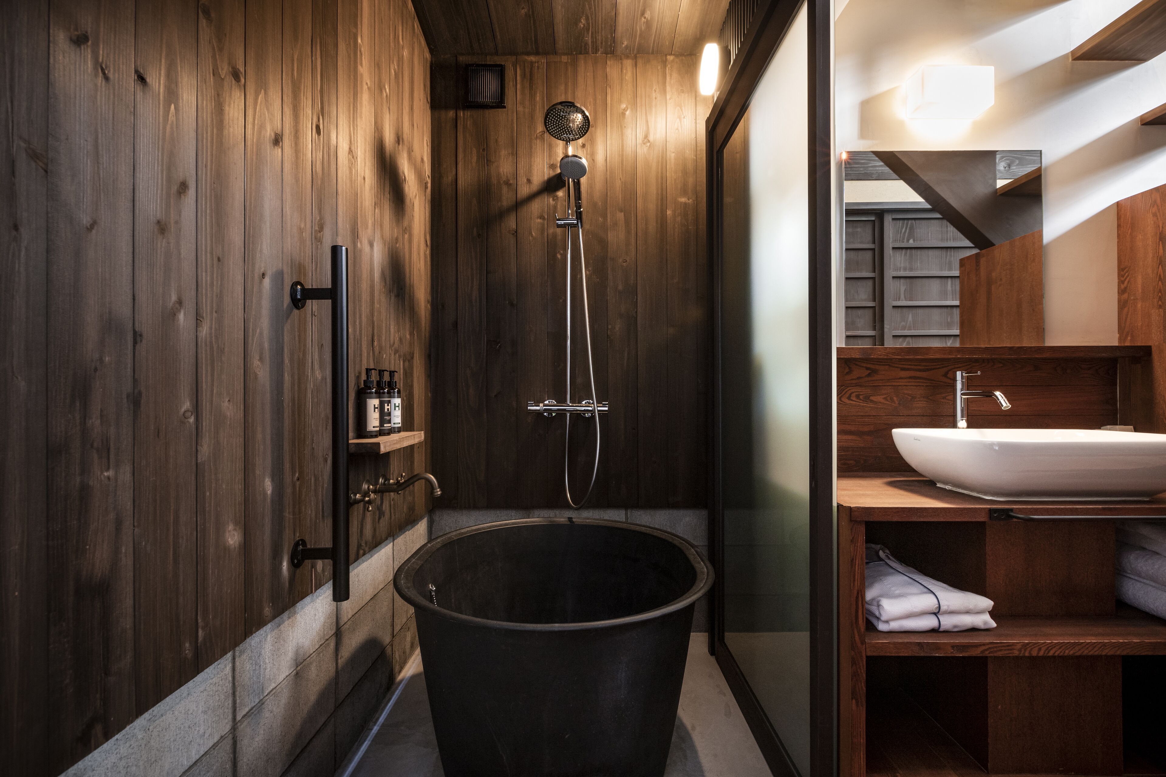 A wooden interior with a bathtub, a sink, and a shower.