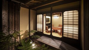 Perinteinen japanilainen huone, jossa on tatamimatto, matala puupöytä ja shoji-liukuovet.