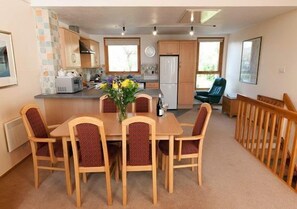 Cozy living space with a central dining area and modern kitchen, perfect for relaxation and casual dining.