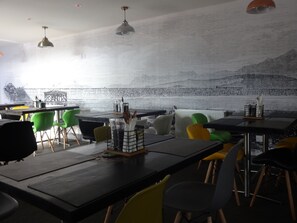 Enjoy a casual dining experience in a spacious restaurant with comfortable seating and unique textured walls.