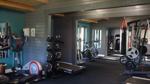 A gym with various exercise equipment including treadmills, stationary bikes, and weight machines. - Ryans Retreat, shepherds hut, pet friendly close to beach and Hadrian's Wall (Bowness on Solway)