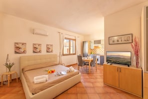 Ein Hotelzimmer mit einem Bett, einem Schreibtisch, einem Fernseher und Kunstwerken an den Wänden.