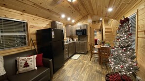 Ein gemütliches Blockhaus-Interieur mit Küchenzeile, Essbereich und Wohnzimmer mit Kamin.