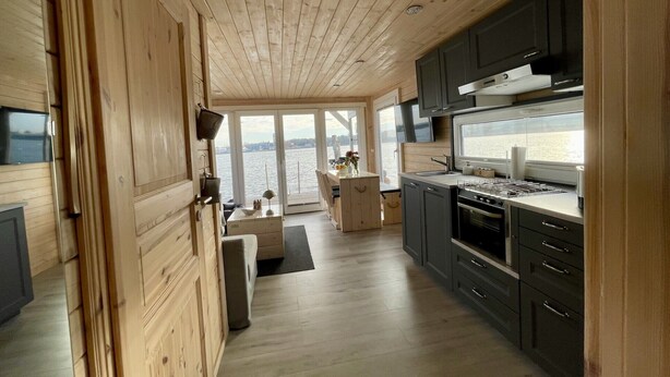 Eine moderne Küche mit Holzausstattung, einem Herd und Blick auf das Wasser.