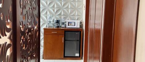 Una cocina moderna con microondas, cafetera y refrigerador.