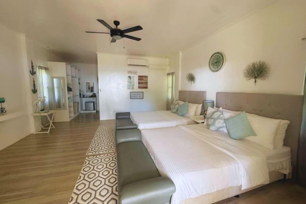 Une chambre à coucher avec un lit, un ventilateur de plafond et un tapis à motifs.