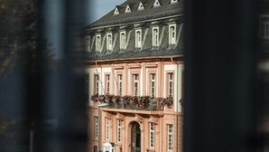 A building with a pink facade, multiple windows, and a green awning. - zur Krone (Leimen)