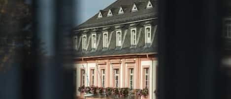 A building with a pink facade, multiple windows, and a green awning.