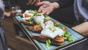 A tray with toast topped with poached eggs, avocado, and greens. - zur Krone (Leimen)