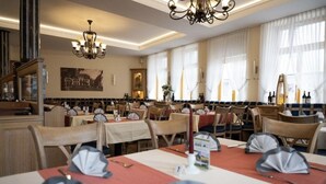 A restaurant with multiple tables set for dining, featuring a classic interior with chandeliers and large windows. - zur Krone (Leimen)