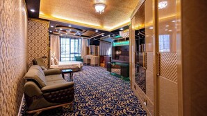 Um quarto luxuoso com carpete estampado, um sofá, uma televisão e teto decorativo.