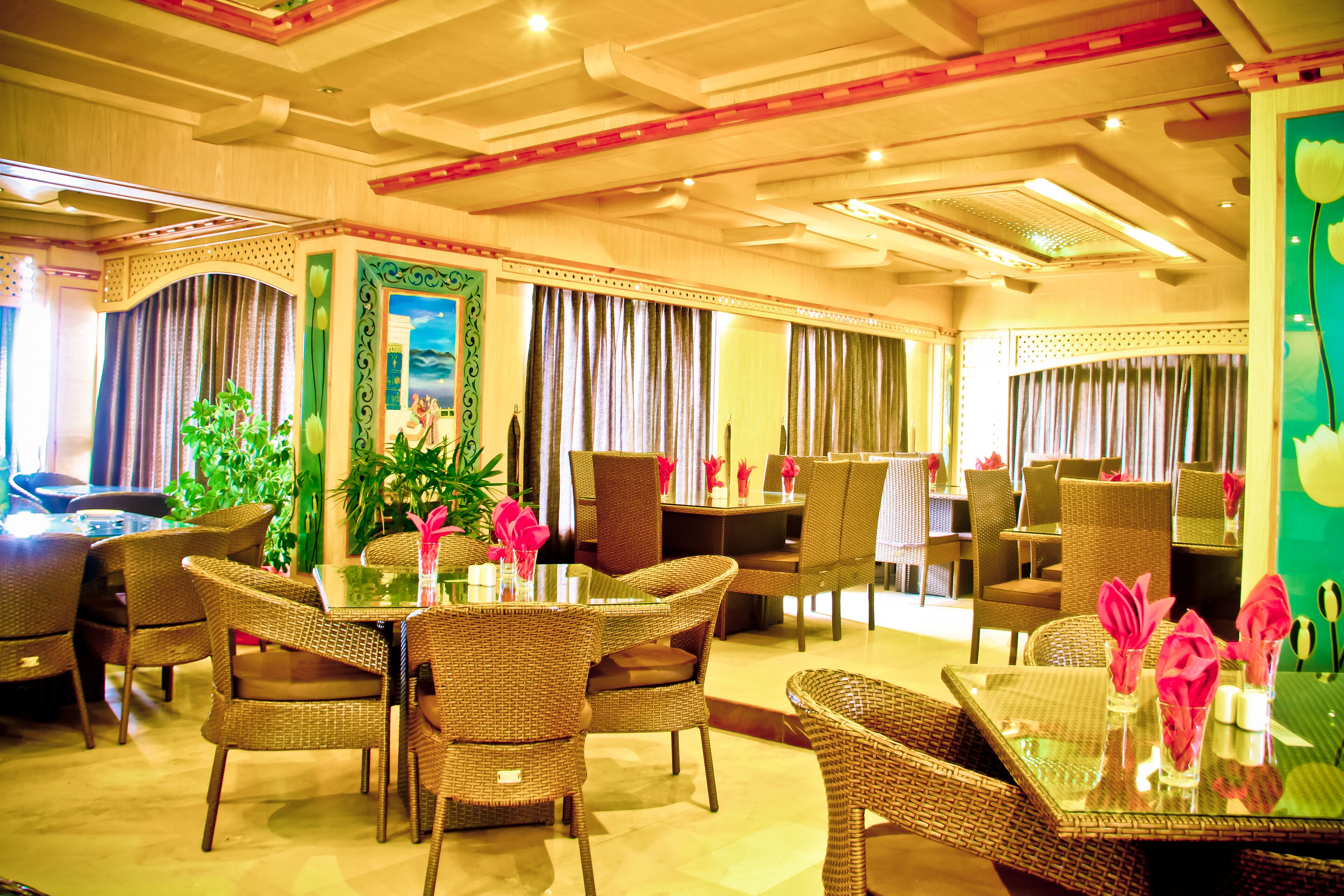A dining area with wicker furniture, glass tables, and curtains.