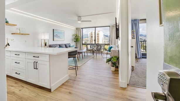 Un apartamento moderno con cocina, comedor y balcón con vista a la ciudad.