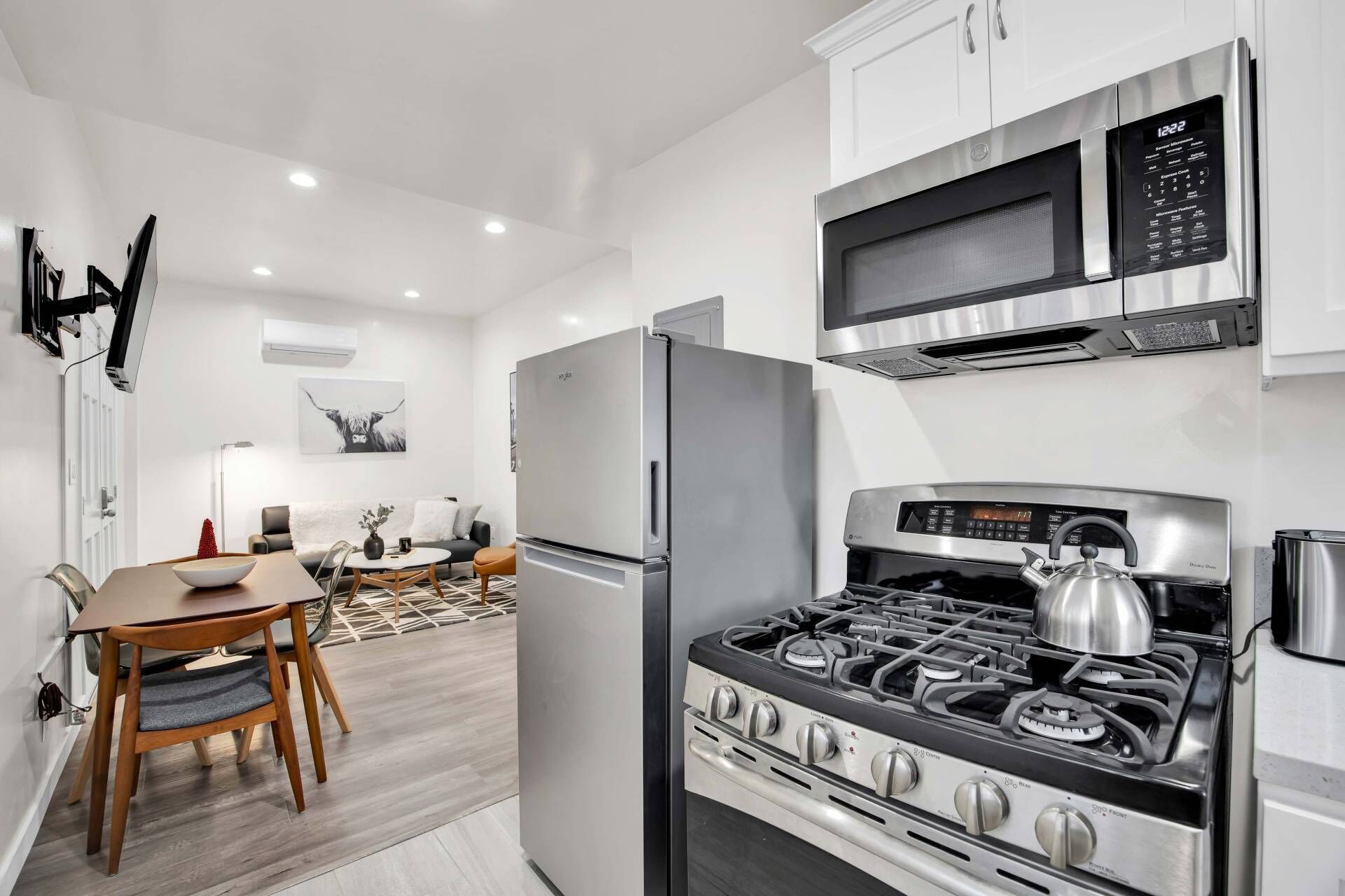 A modern kitchen with a stainless steel stove, microwave, and refrigerator.