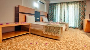 Una camera d'albergo con un letto, una scrivania e un comodino.