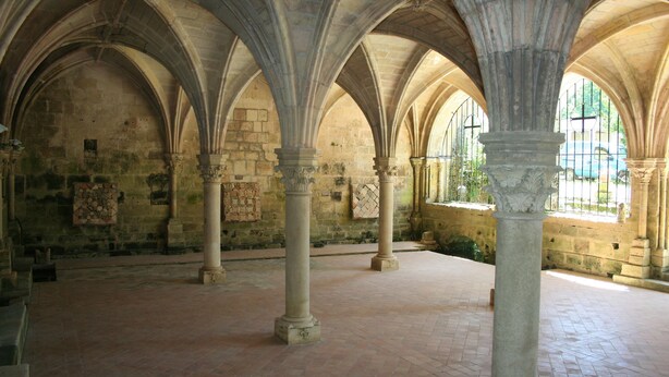 A spacious interior with high vaulted ceilings and stone columns.