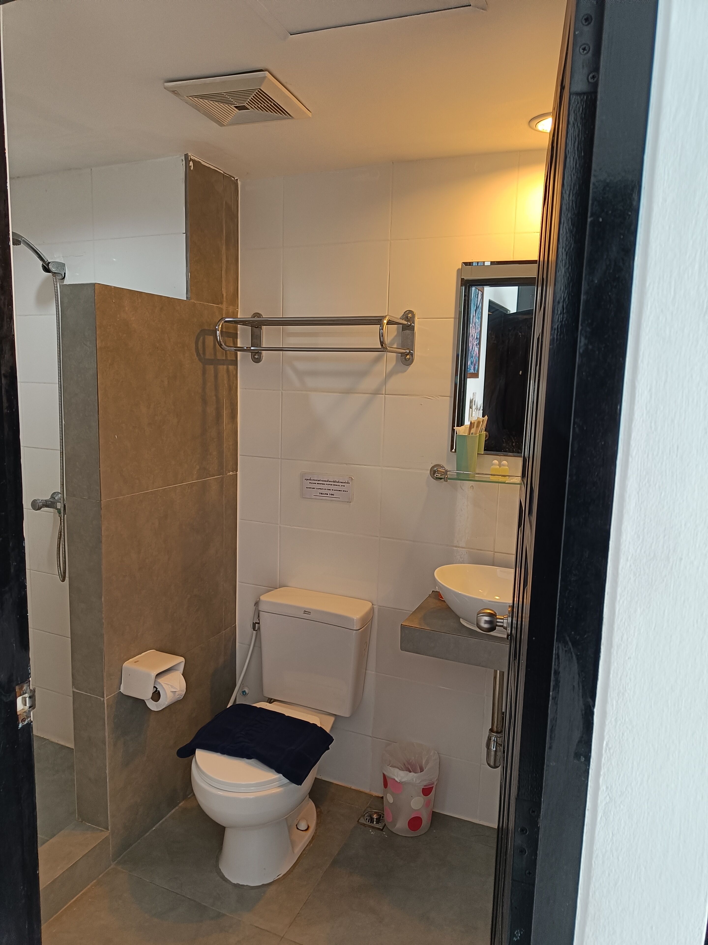 A bathroom with a toilet, shower, and sink.