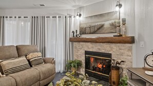 Uma sala de estar com lareira, sofá e mesa de centro.