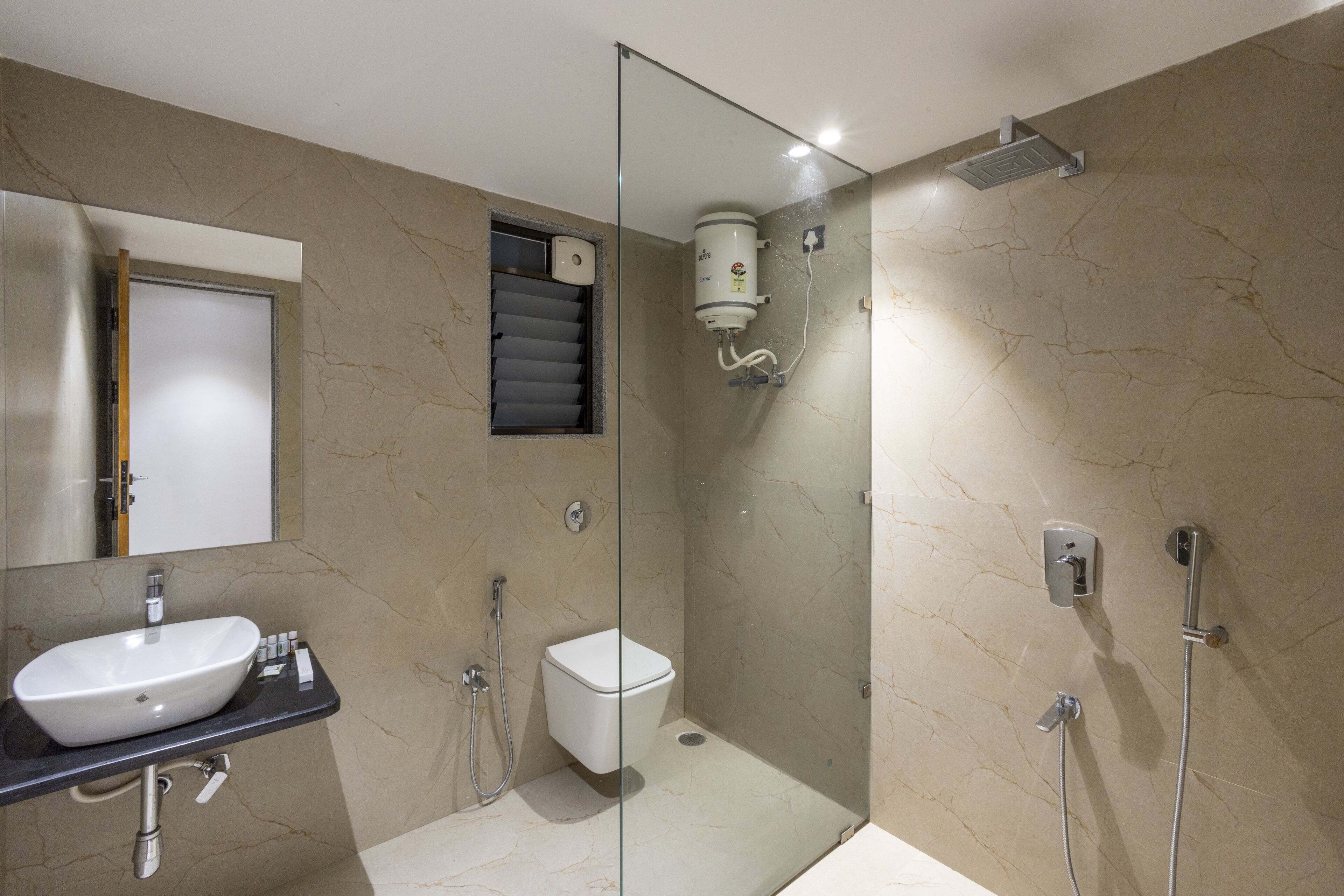 Un baño moderno con ducha de vidrio, lavamanos e inodoro.