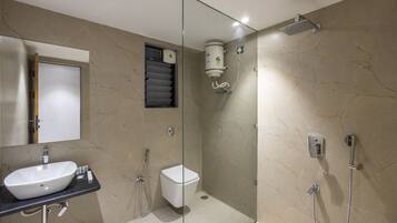 Een moderne badkamer met een douchecabine van glas, een wastafel en een toilet.