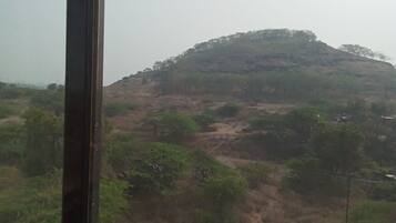 Vista de un paisaje montañoso con vegetación escasa y un sendero de tierra.