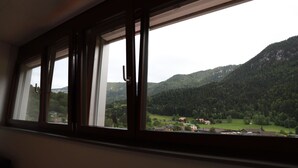 Une pièce dotée d’une grande fenêtre donnant sur un paysage montagneux.