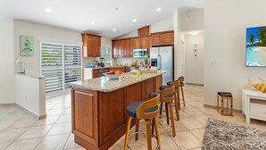 A modern kitchen with a central island, wooden cabinets, and a bar area with stools. - Private Pool｜Near Beach｜Fenced Yard｜Outdoor Living (Naples)