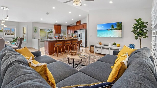 A modern living room with a grey sofa, a coffee table, and a TV mounted on the wall. - Private Pool｜Near Beach｜Fenced Yard｜Outdoor Living (Naples)