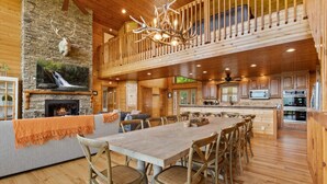 Ein großzügiges Chalet mit einem geräumigen Essbereich, einem Kamin und einem Balkon mit Holzbalkon.