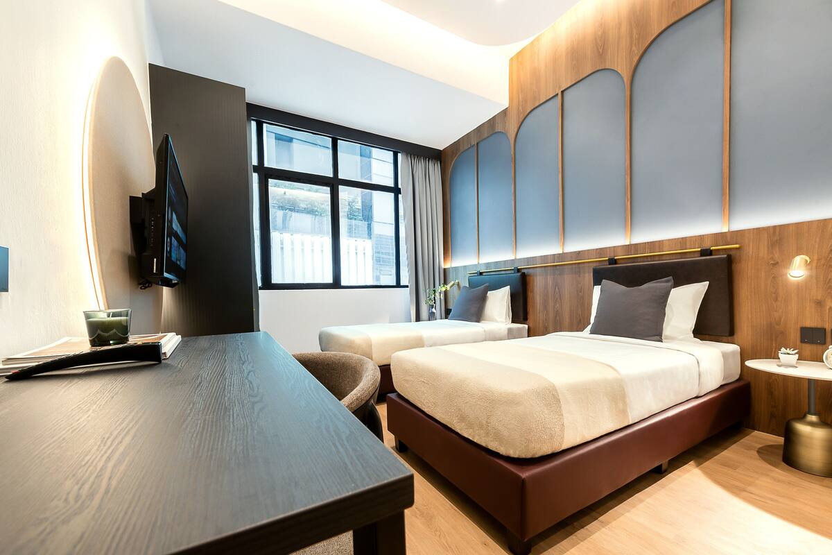 Een moderne hotelkamer met een groot bed, een bureau en een televisie.