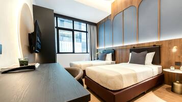 Een moderne hotelkamer met een groot bed, een bureau en een televisie.