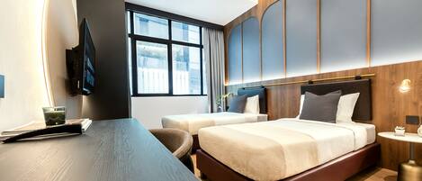 Une chambre d’hôtel moderne, dotée d’un grand lit, d’un bureau et d’une télévision.
