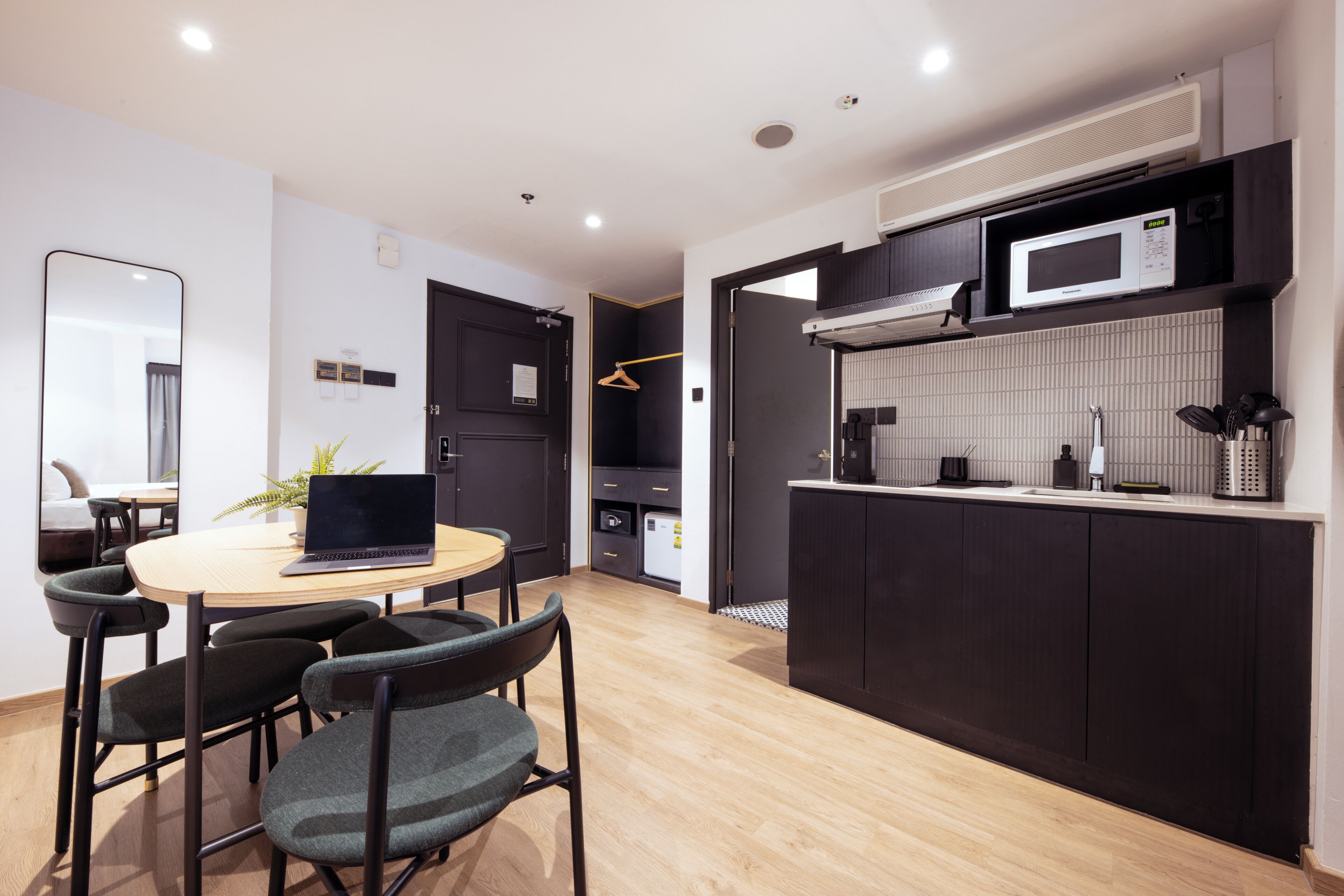 Una cocina moderna con microondas, pileta y alacenas. Cuenta con un comedor con mesa y sillas.