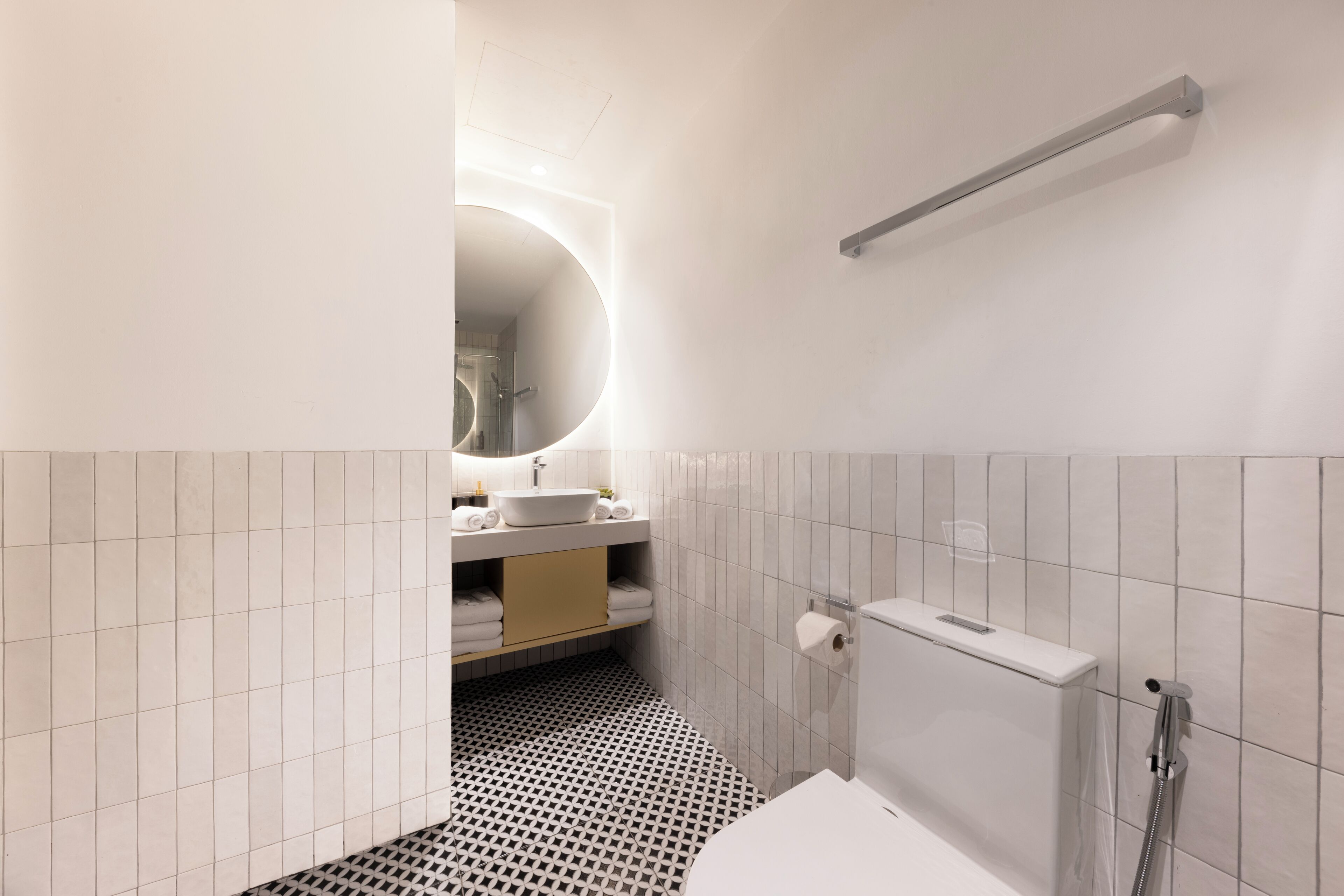 A modern bathroom with a toilet, sink, and mirror.