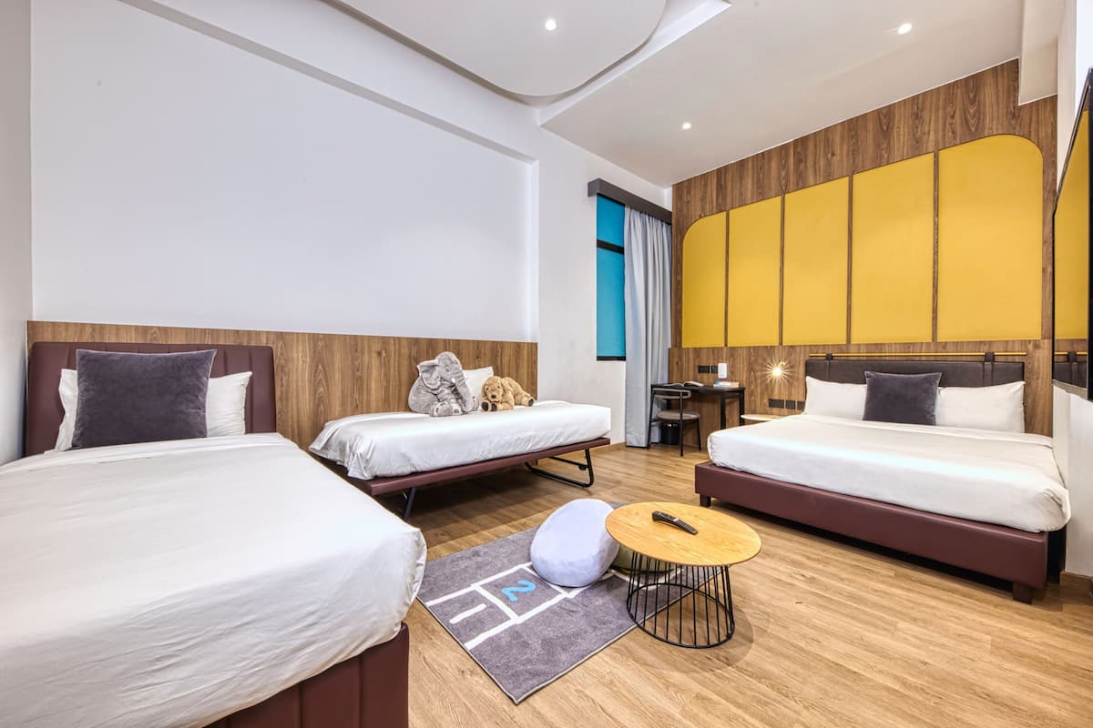 Een moderne hotelkamer met twee bedden, een klein bureau en een bank.