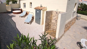 A building with a patio area featuring sun loungers and a small pool. - Charming detached holiday home with private pool–close to beach and fully fenced (Dénia)