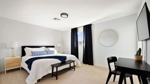 A modern hotel room with a bed, bedside tables, a desk, and a chair. - The Minnezona Modern-Old Town (Scottsdale)