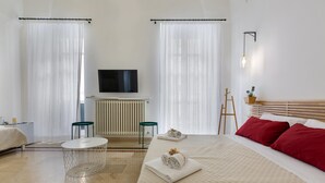 A hotel room with a bed, a TV, a radiator, a small table, and a chair. - 3141 B&b Incentro Comfort Suite - Central Suite by Barbarhouse (Lecce)