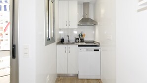 A compact kitchen with white cabinets, a stainless steel range hood, and a dishwasher. - Nice studio near the Beach - AA/CC - UHC ALBORAN 292 (Salou)