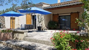 Une terrasse avec des meubles d’extérieur, un vélo et une plante en pot.