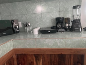 A kitchen counter with a toaster, a blender, a coffee maker, and a kettle. - Remarkable Studio in Jungle of Chemuyil, Tulum (Tulum)
