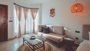 Un salon chaleureux avec un canapé, une table basse en bois et un tapis à motifs.