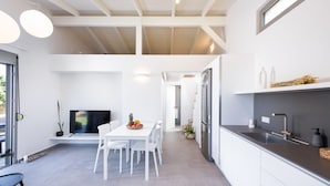 A modern kitchen with white cabinetry, a built-in oven, and a stainless steel sink.