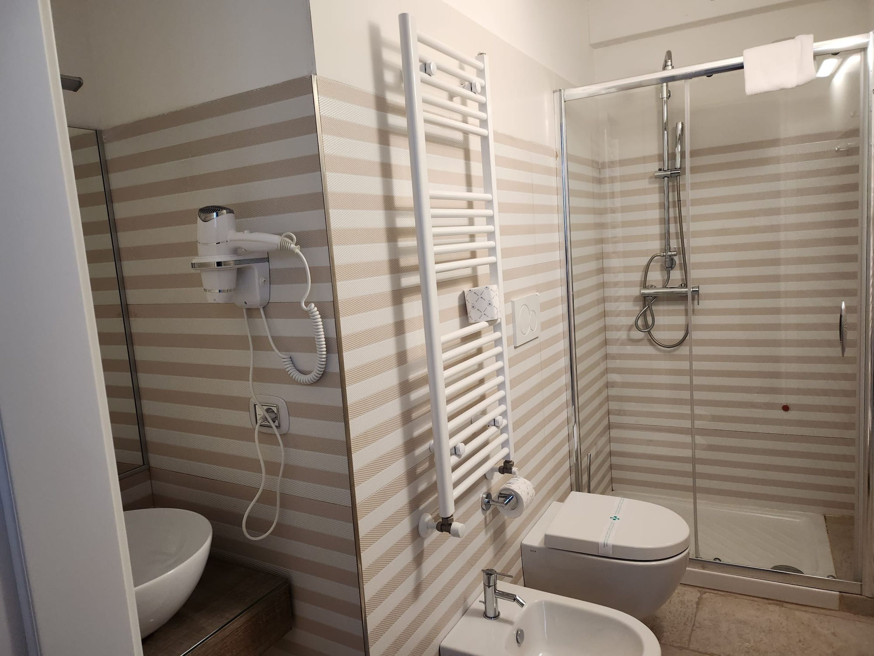 Un baño con inodoro, lavamanos y ducha.