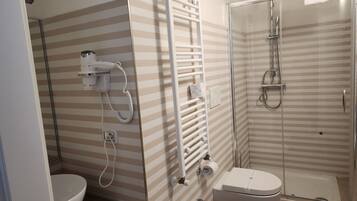 Un baño con inodoro, lavamanos y ducha.