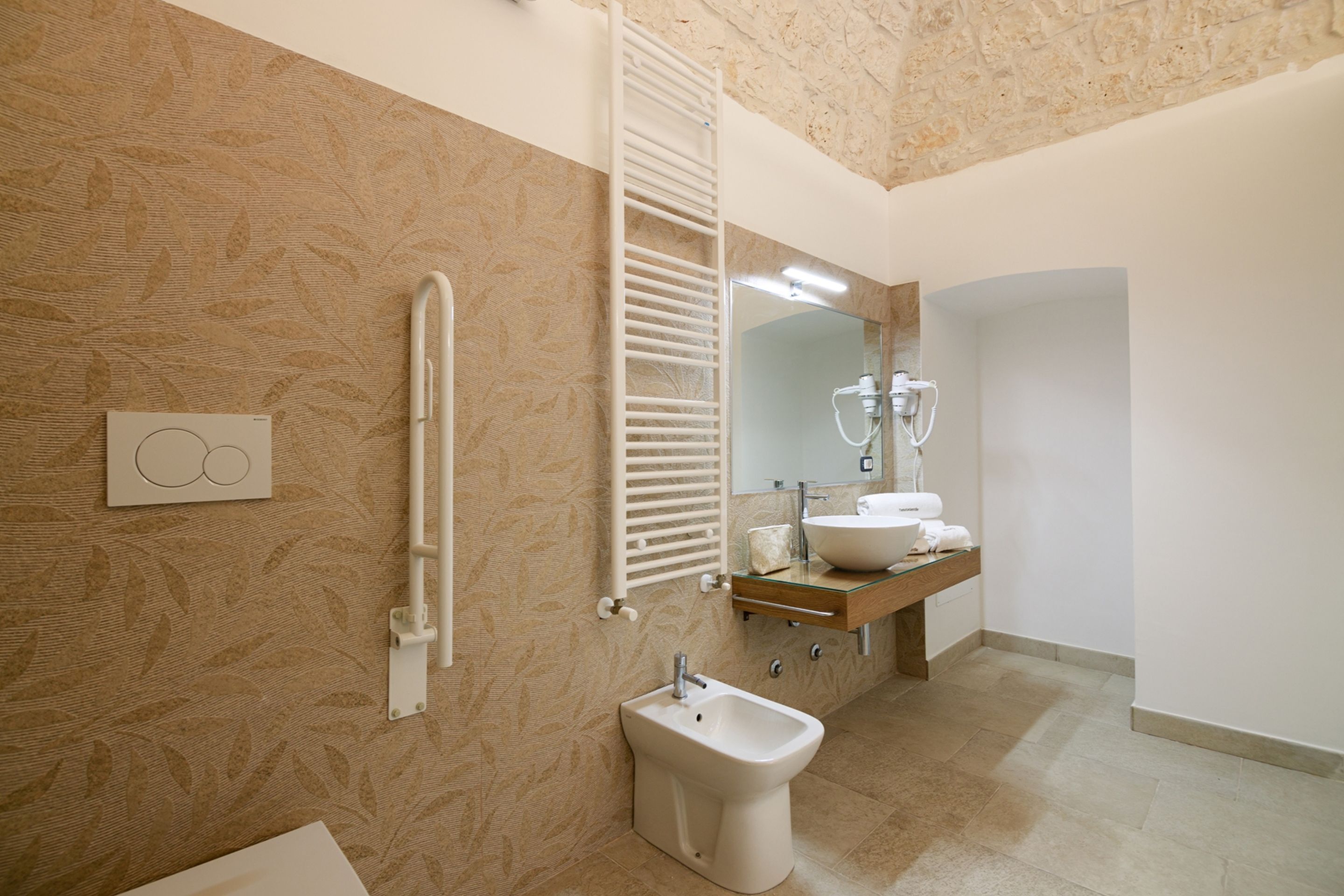Un bagno moderno con bidet, porta asciugamani, specchio e lavandino.