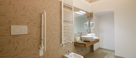 Casa de banho moderna com bidé, porta-toalhas, espelho e lavatório.