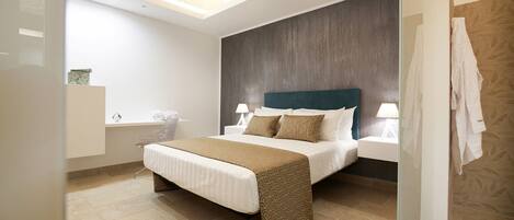 A modern bedroom with a large bed, bedside tables, a skylight, and a shower area.